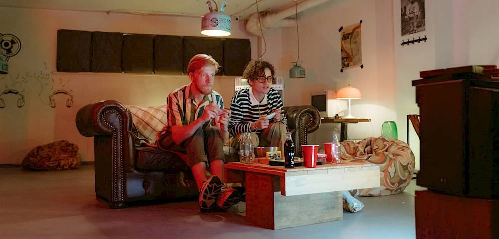 2 Jugendliche auf dem Sofa beim Zocken